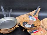deux casseroles et une poêle posées sur une table