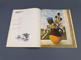 an open book with a picture of a vase with flowers in it