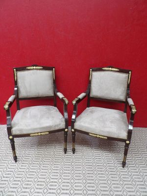 Deux fauteuils de style Empire en bois teinté, recouvert de …