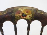 a wooden chair with a floral design on the back