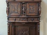 a wooden cabinet with carvings on top of it