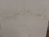 a white refrigerator sitting in the corner of a room
