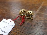 a tag on a wooden table with a pair of gold bells