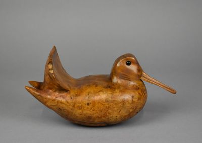 une image représentant un oiseau en bois posé sur une table