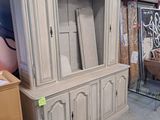 une armoire blanche avec une porte vitrée au milieu d'une pièce