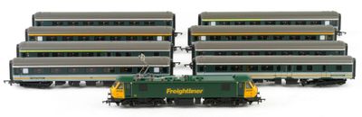 three green and yellow train cars sitting next to each other on a white surface