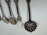 a lot of spoons and forks that are hanging on the wall