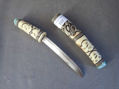 une image représentant un couteau au manche sculpté posé sur une table