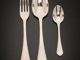 three spoons, a fork and a spoon on a table