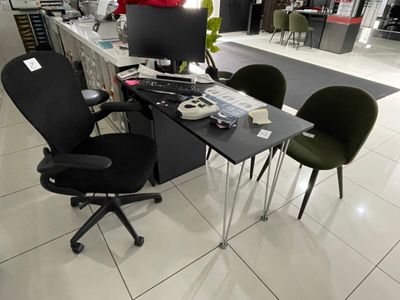 un bureau équipé d'un ordinateur et de deux chaises dans un magasin