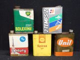 cinq boîtes d'huile posées sur une surface noire