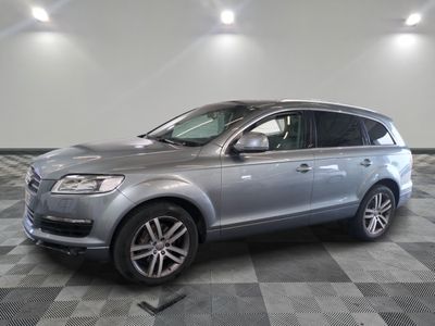 une photo d'un SUV Audi argenté garé dans un showroom