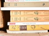 many books in a cardboard box on top of each other