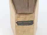 an old book that is open on a white surface