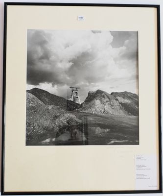 photographie en noir et blanc d'un phare au milieu d'une chaîne de montagnes