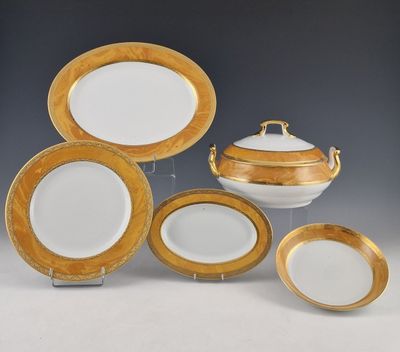 un lot d'assiettes plates dorées et blanches et un plat à gratin