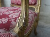 a pink and gold chair with a pink cushion on it