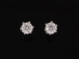 a pair of diamond earrings on a black surface