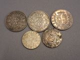 six pièces de monnaie britanniques différentes posées sur une table