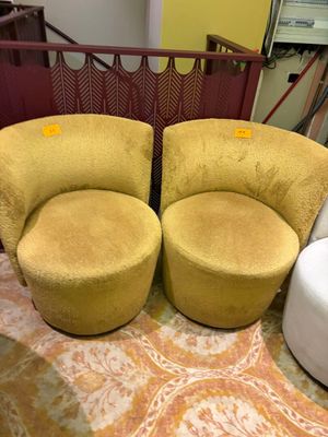 two yellow and white chairs and a white ottoman in a room
