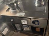 une cuisinière en acier inoxydable sur laquelle est posée une casserole