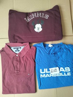 three t - shirts are sitting on a cardboard box on the floor