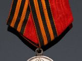 two medals and a medal on a table with a red ribbon