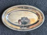 une assiette en argent sur laquelle se trouve une souris, posée sur un tapis bleu