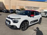 la petite voiture blanche est garée devant un bâtiment
