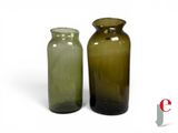 two green vases sitting next to each other on a white surface