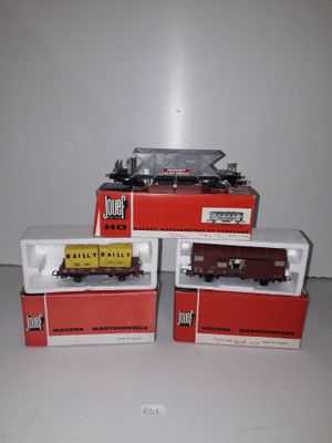 four toy trains sitting on top of boxes on a white surface