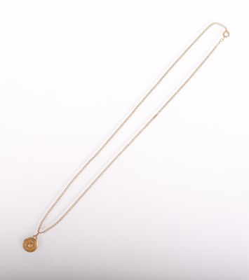 a gold necklace with a coin on a white background