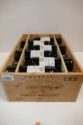 des bouteilles de vin dans une caisse en bois posée sur une table blanche