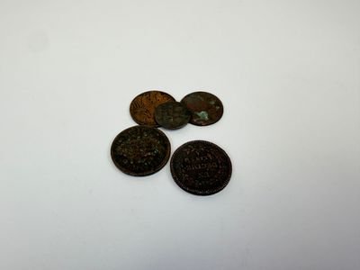 trois vieilles pièces empilées les unes sur les autres sur une surface blanche