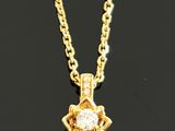 an image of a diamond pendant on a chain on a black surface