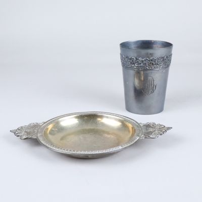 une assiette en argent et une tasse en argent posées sur une table blanche
