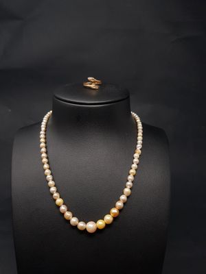 a pearl necklace with a gold clasp on a mannequin