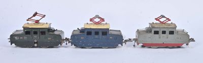 trois petits trains jouets posés côte à côte dans la neige