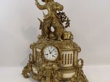 a gold clock with a statue on top of it