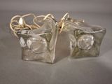two clear glass vases with gold handles on a table