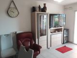 un salon avec un fauteuil rouge et une télévision accrochée au mur