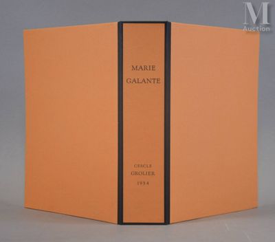 Un livre orange orné d'une bande noire est ouvert sur une table.