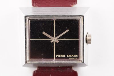une montre posée sur un bracelet rouge