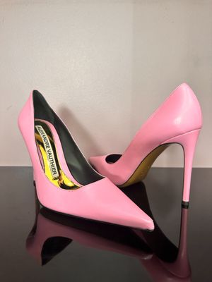 a pair of pink high heels on a black surface