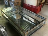 une table basse avec un plateau en verre dans une pièce