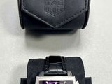 purple and black watch and case on a white surface