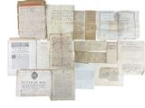 several old papers are stacked on top of each other on a white surface