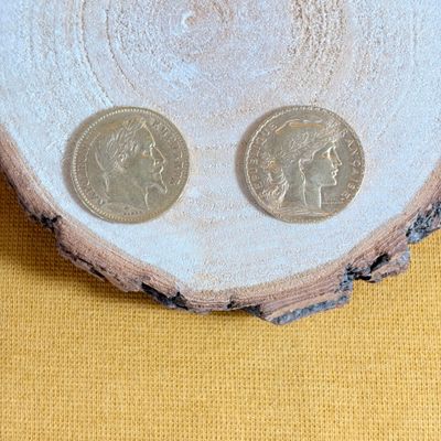 two coins sitting on top of a piece of wood