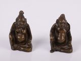 une paire de figurines en bronze représentant un homme et une femme assis à genoux