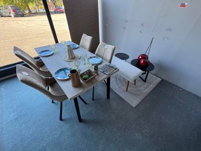 a table and chairs in a room with a large window